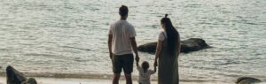 Un couple et leur enfant de dos, face à la mer, symbolisant la protection et l’accompagnement juridique qu’un avocat en droit de la famille en Thaïlande peut offrir.