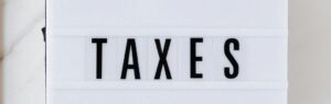 Impôts en Thaïlande pour les expatriés : panneau lumineux affichant le mot 'TAXES', représentant les obligations fiscales des expatriés en Thaïlande.