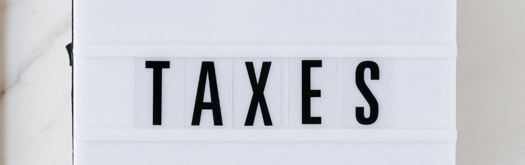 Impôts en Thaïlande pour les expatriés : panneau lumineux affichant le mot 'TAXES', représentant les obligations fiscales des expatriés en Thaïlande.