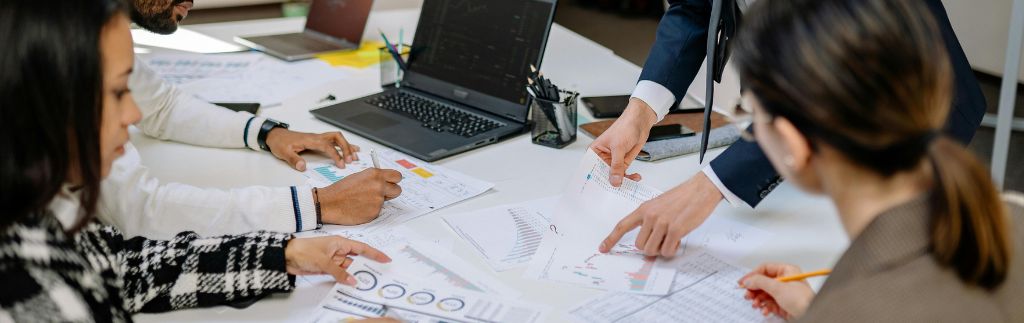 Business professionals analyzing financial charts and investment data during a meeting about a BOI Bangkok project.