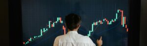 Homme analysant les tendances de l'économie numérique en Thaïlande sur un écran de données financières