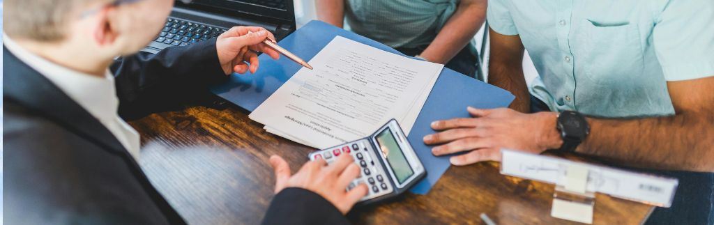 Trois personnes discutant autour de documents financiers lors d’une réunion sur des fonds d'investissement en Thaïlande.