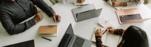 Group of professionals in a meeting with laptops and notebooks, representing teamwork and opportunities to work in Thailand