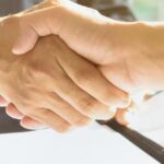 Handshake after signing a share purchase agreement in Thailand between foreign investor and Thai company