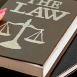 Law book with scales of justice – symbol of competition law in Thailand
