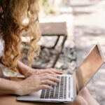 Digital nomad in Thailand working remotely by the pool on a laptop