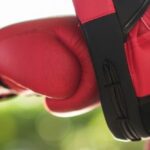 Allenamento di Muay Thai con guantoni rossi, simbolo del visto DTV per praticare sport in Thailandia.