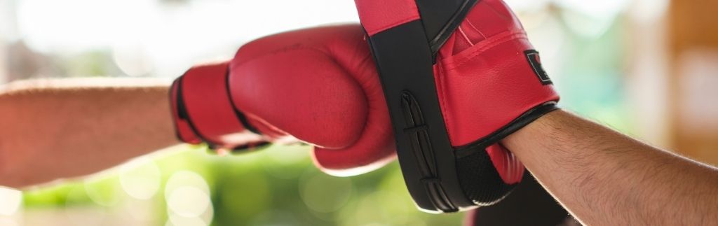 Allenamento di Muay Thai con guantoni rossi, simbolo del visto DTV per praticare sport in Thailandia.
