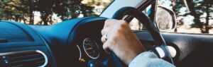 Persona alla guida di un’auto, simbolo della necessità di una patente di guida internazionale in Thailandia per i conducenti stranieri.