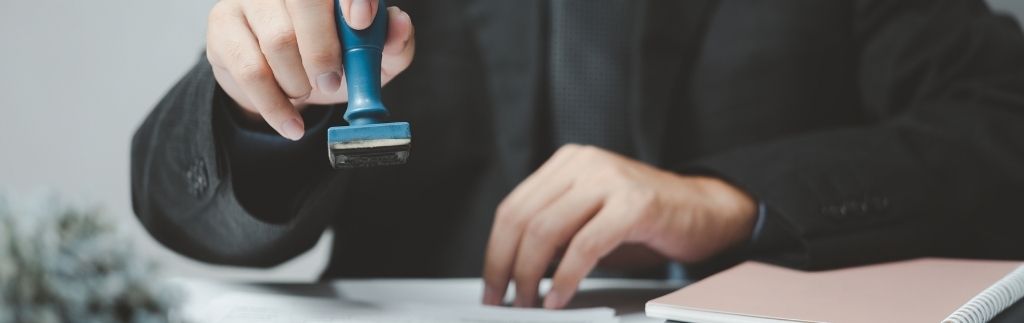 Funzionario che timbra documenti ufficiali, simbolo delle procedure amministrative per l’ingresso Thailandia e il controllo dei visti.