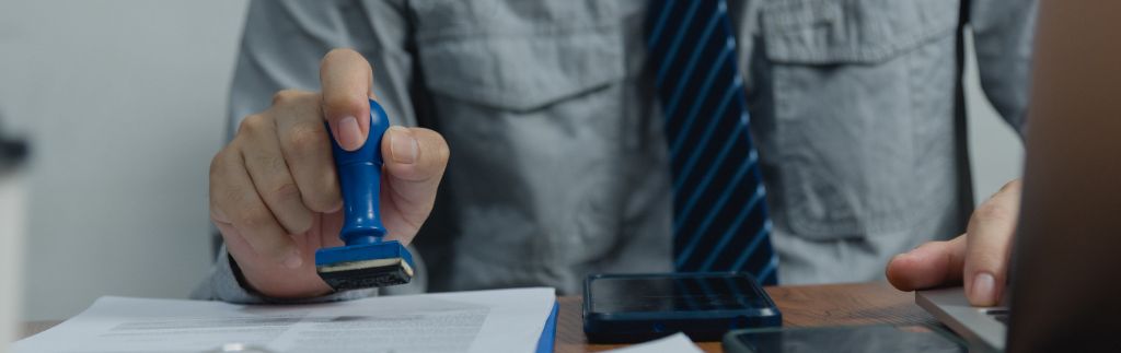 Funzionario timbra documenti ufficiali – simbolo della richiesta visto Thailandia e delle procedure amministrative.