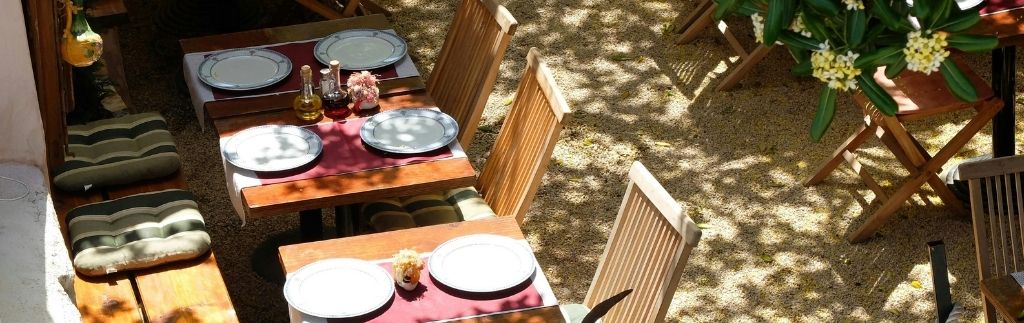 Открыть ресторан в Таиланде — уютная открытая терраса с сервированными столами и деревянной мебелью