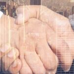 Handshake over a city skyline symbolizing the business partnership enabled by the Treaty of Amity between the U.S. and Thailand.