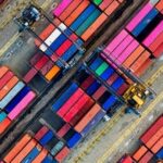 Container colorati in un porto commerciale, simbolo delle attività di import export in Thailandia.