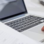 Uomo che lavora al computer mentre prepara documenti per richiedere il visto per vivere in Thailandia