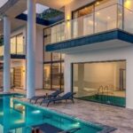 Villa moderna con piscina a sfioro al tramonto, esempio di ville in Thailandia immerse nella natura