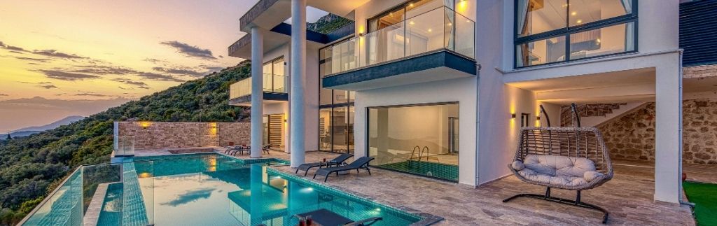 Villa moderna con piscina a sfioro al tramonto, esempio di ville in Thailandia immerse nella natura