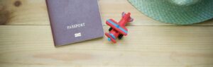 Семейная виза Таиланд для супругов и детей LTR, паспорт и игрушечный самолет на деревянной поверхности.