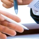 Business professionals reviewing legal documents related to factory license Thailand during an approval process