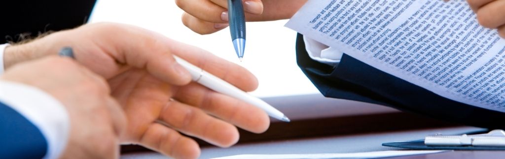 Business professionals reviewing legal documents related to factory license Thailand during an approval process