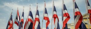 Thailändische Flaggen vor einem Regierungsgebäude – Symbol für die thailändische Staatsbürgerschaft.