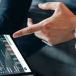 Zwei digitale Nomaden besprechen Finanzdaten auf einem Tablet – Symbol für ortsunabhängiges Arbeiten mit dem Nomadenvisum Thailand 2025.