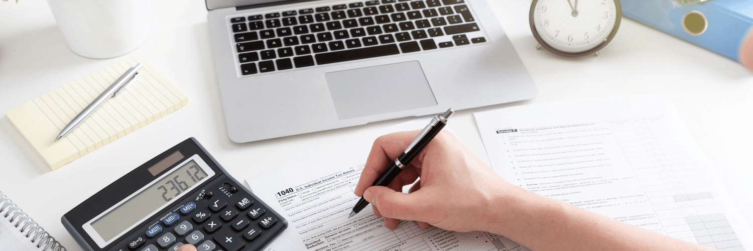 ordinateur et calculatrice et main qui écrit